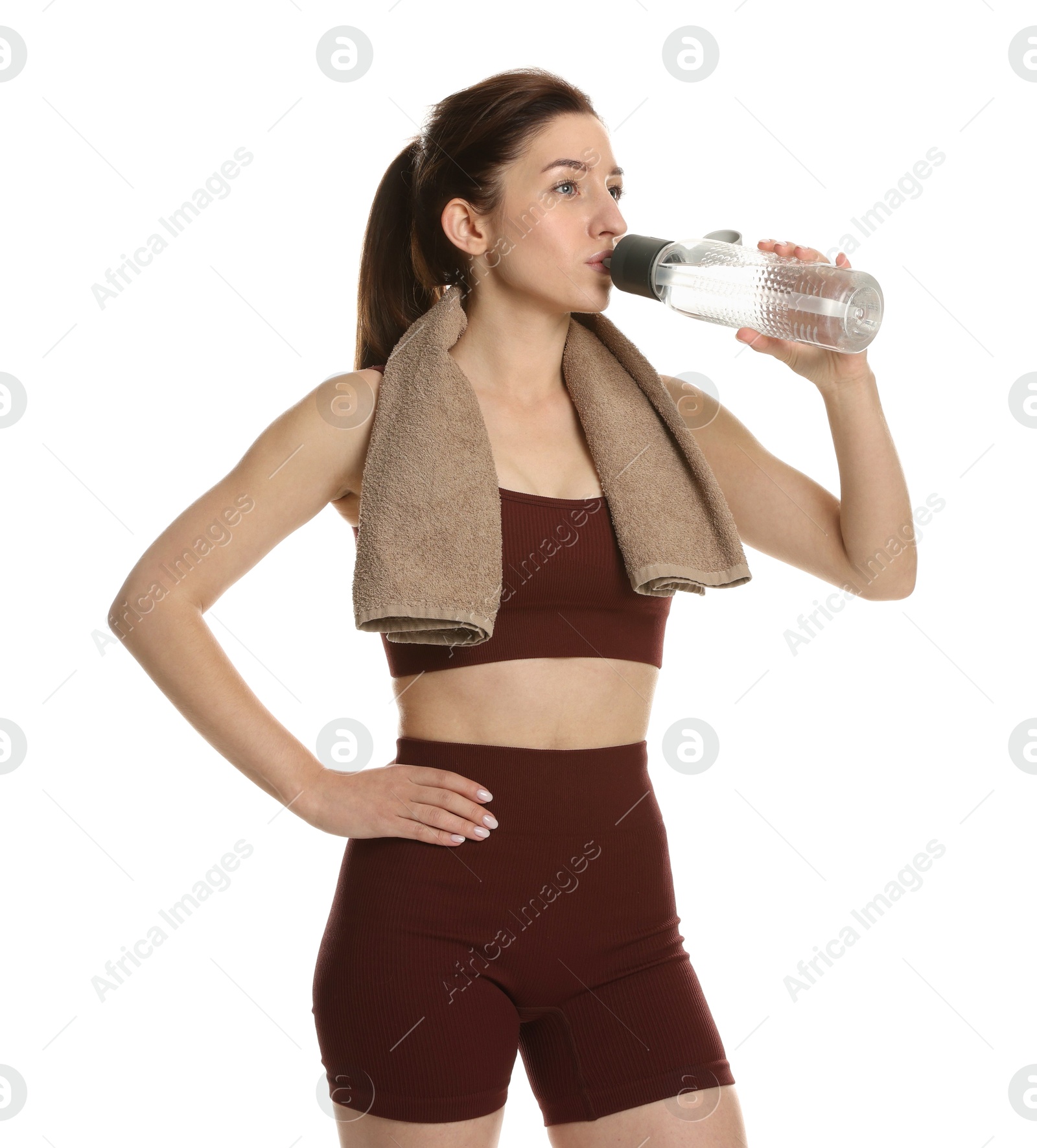 Photo of Woman in sportswear drinking water on white background