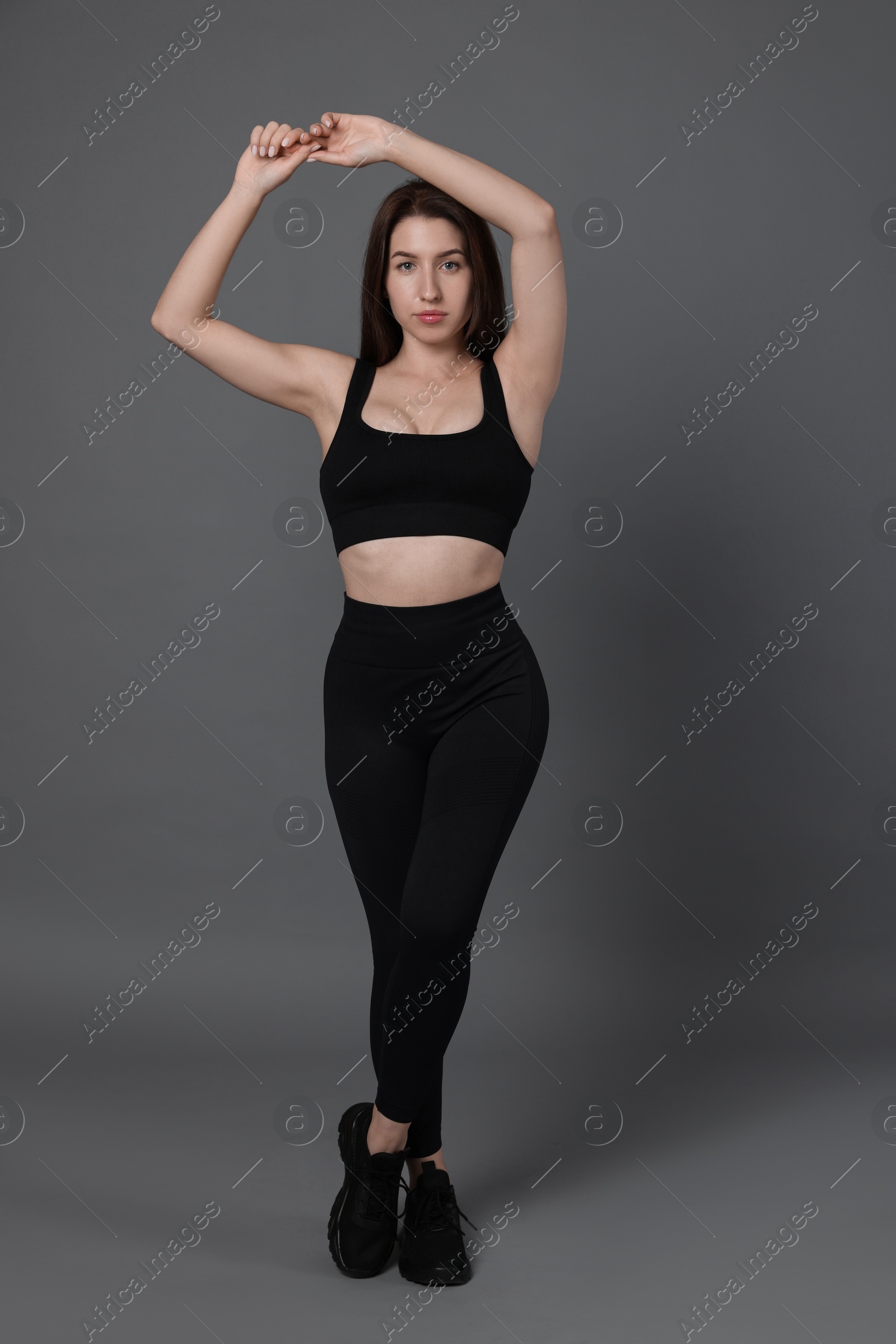 Photo of Portrait of woman in sportswear on grey background