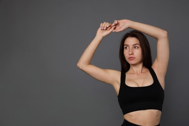 Photo of Portrait of woman in sportswear on grey background, space for text