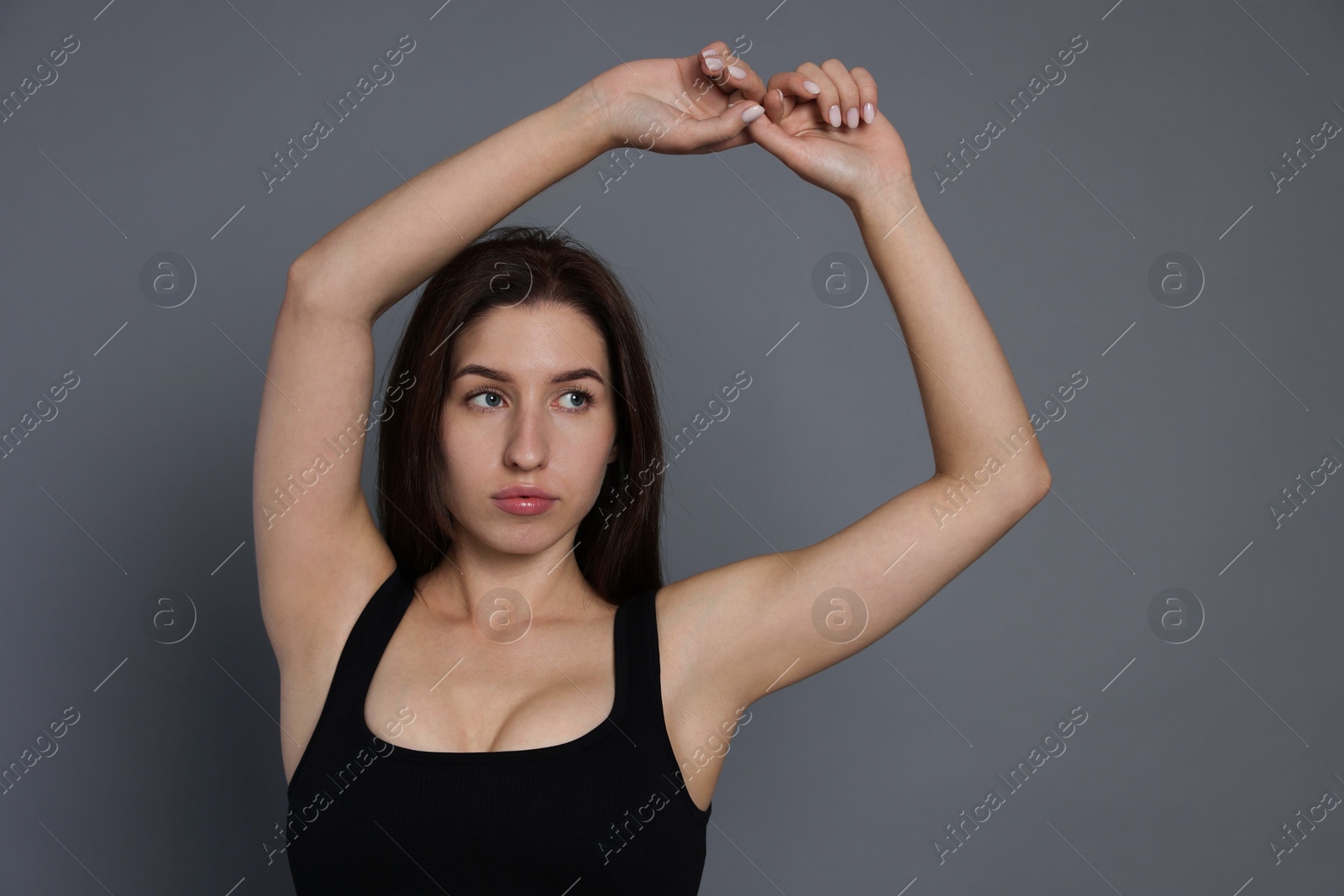 Photo of Portrait of woman in sportswear on grey background