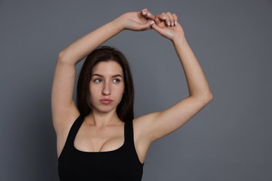 Photo of Portrait of woman in sportswear on grey background