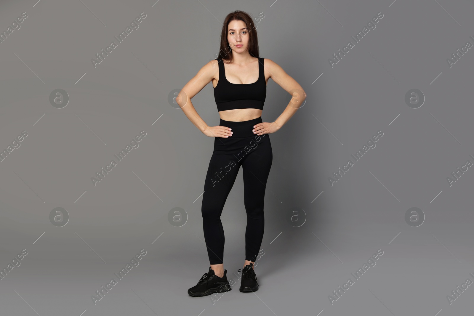 Photo of Portrait of woman in sportswear on grey background