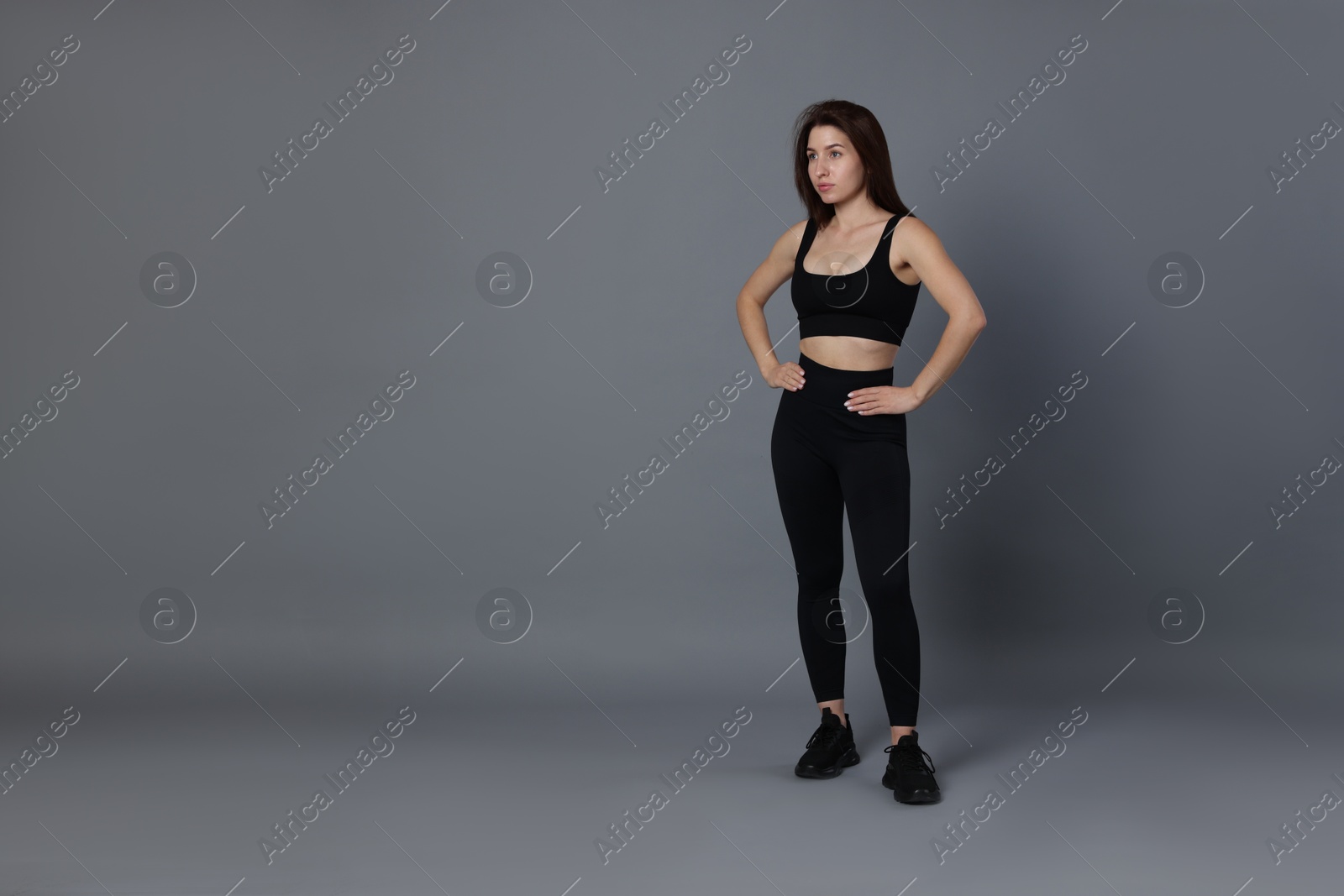 Photo of Portrait of woman in sportswear on grey background, space for text