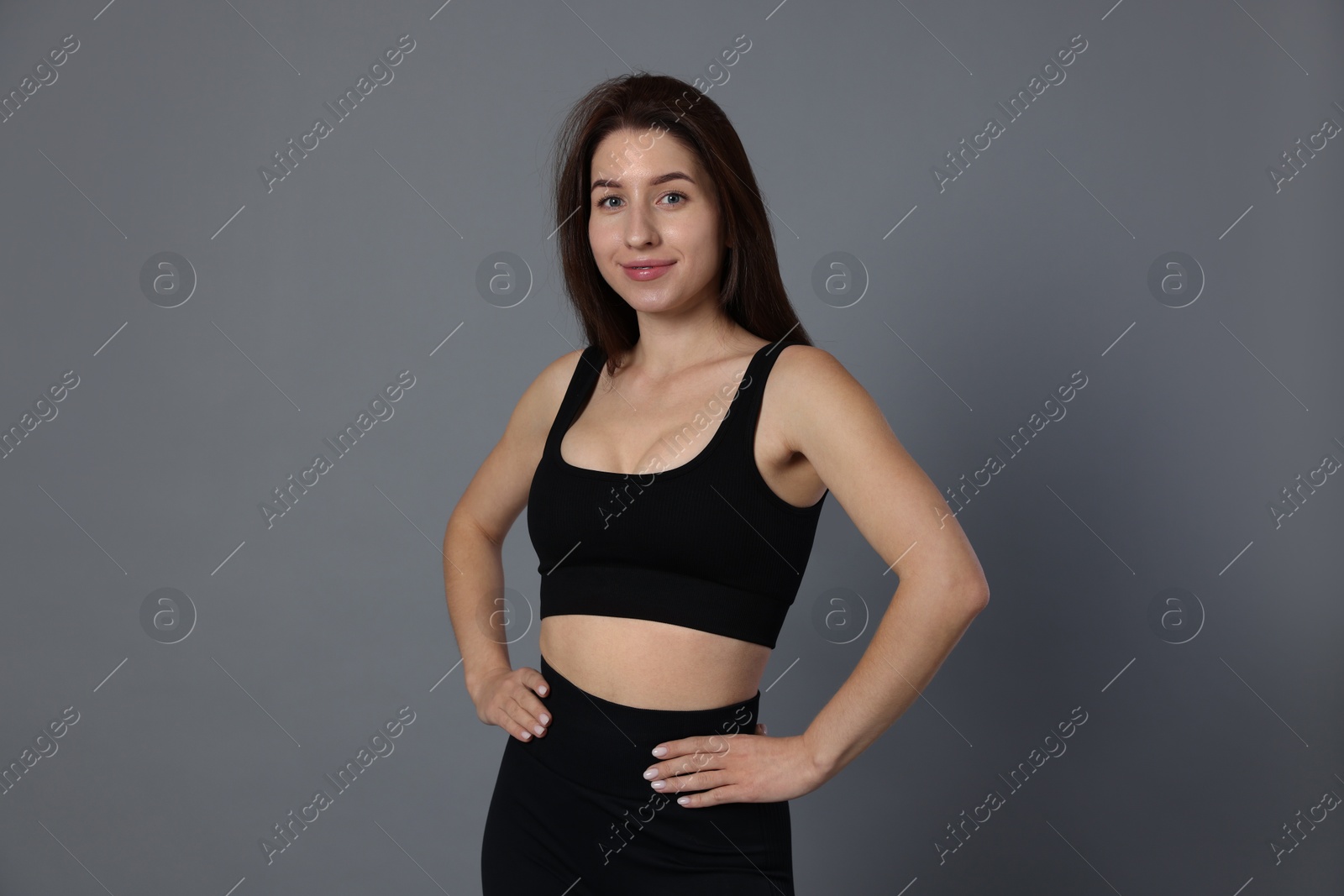 Photo of Portrait of woman in sportswear on grey background