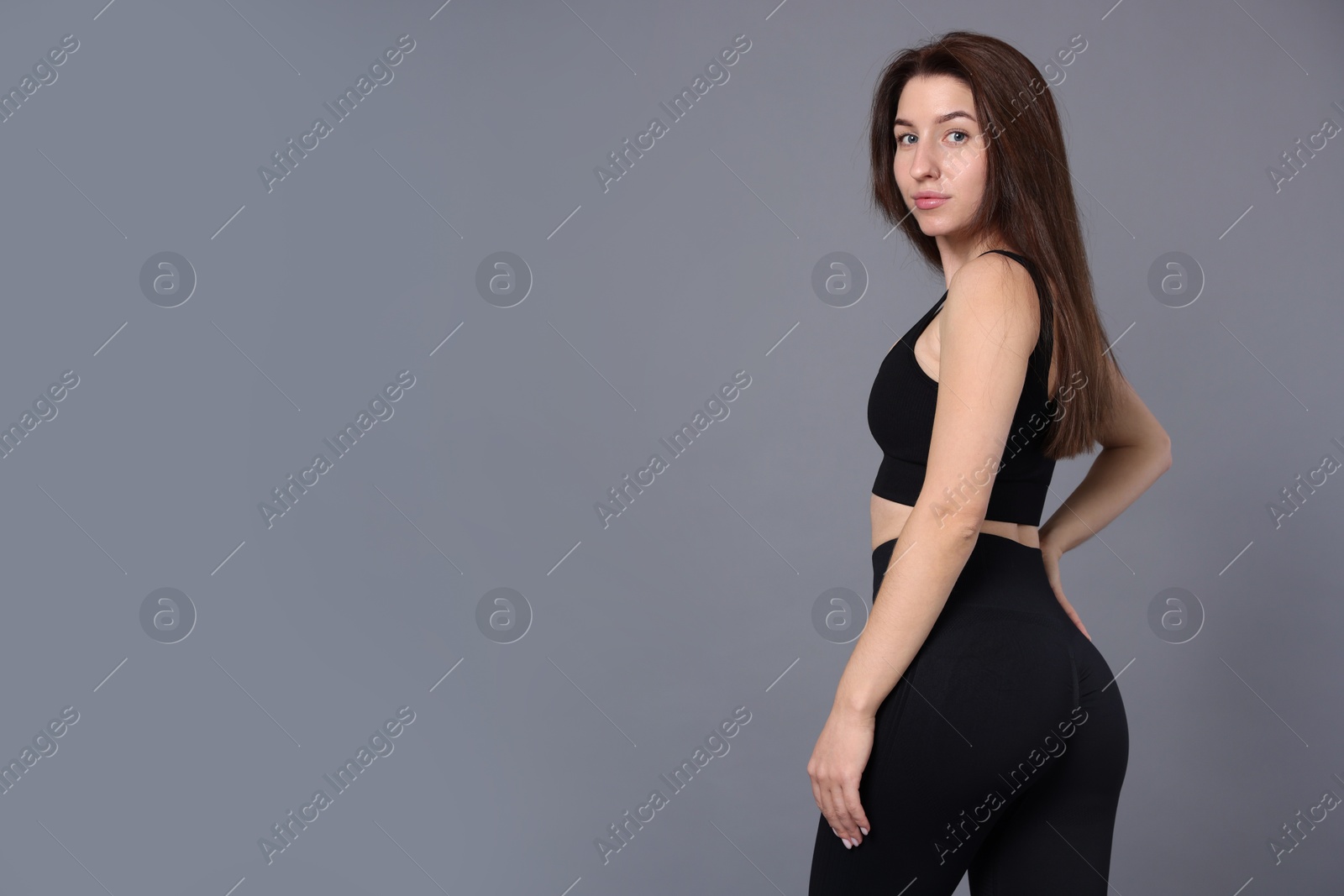 Photo of Portrait of woman in sportswear on grey background, space for text