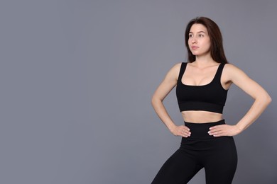 Photo of Portrait of woman in sportswear on grey background, space for text