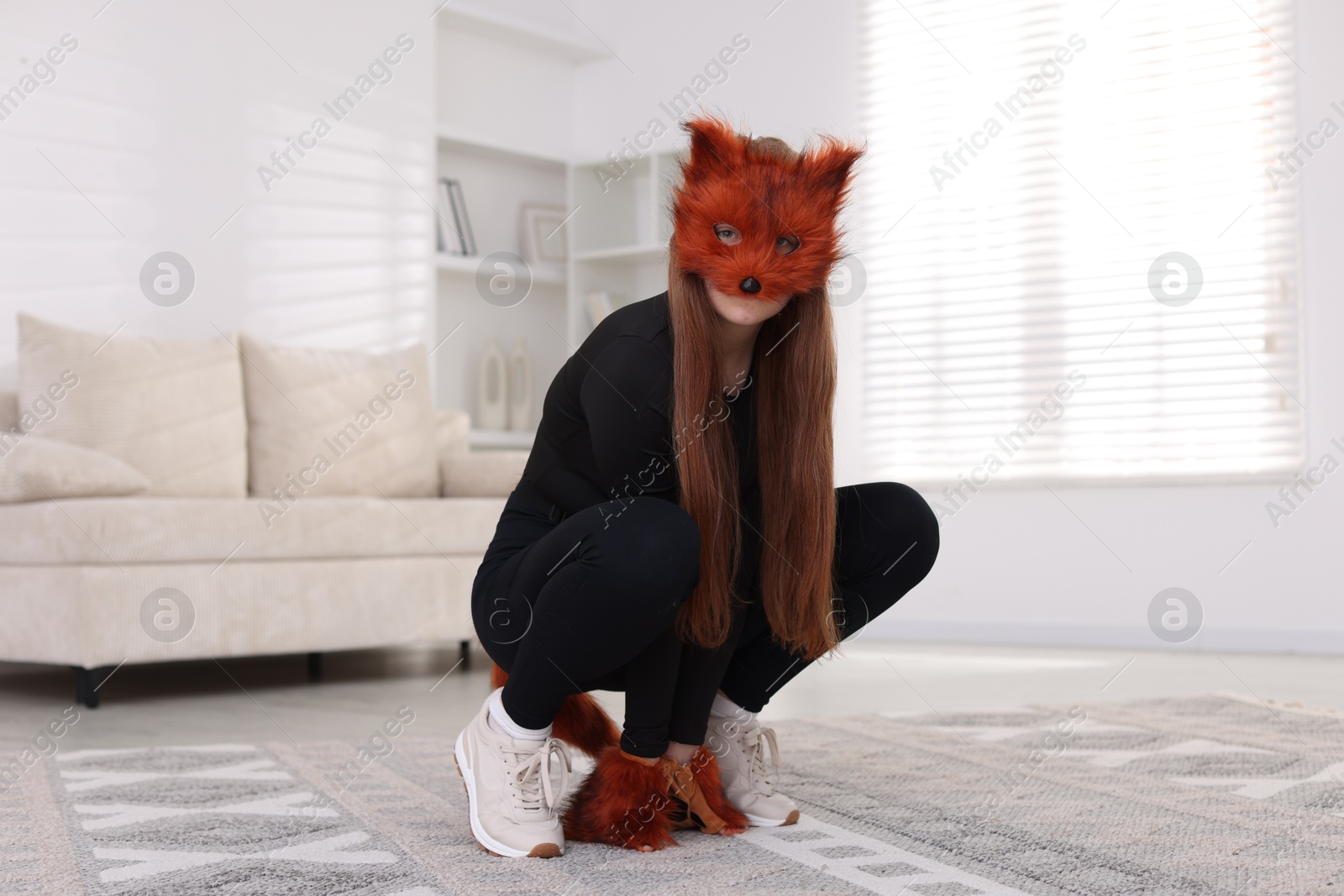 Photo of Quadrobics. Girl wearing fox mask and gloves at home