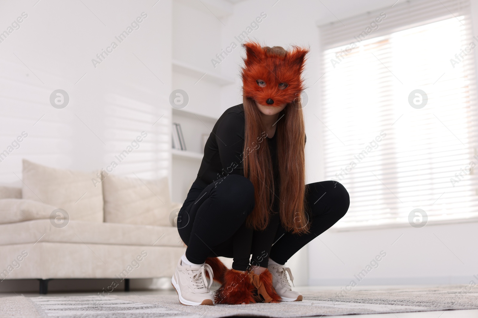 Photo of Quadrobics. Girl wearing fox mask and gloves at home