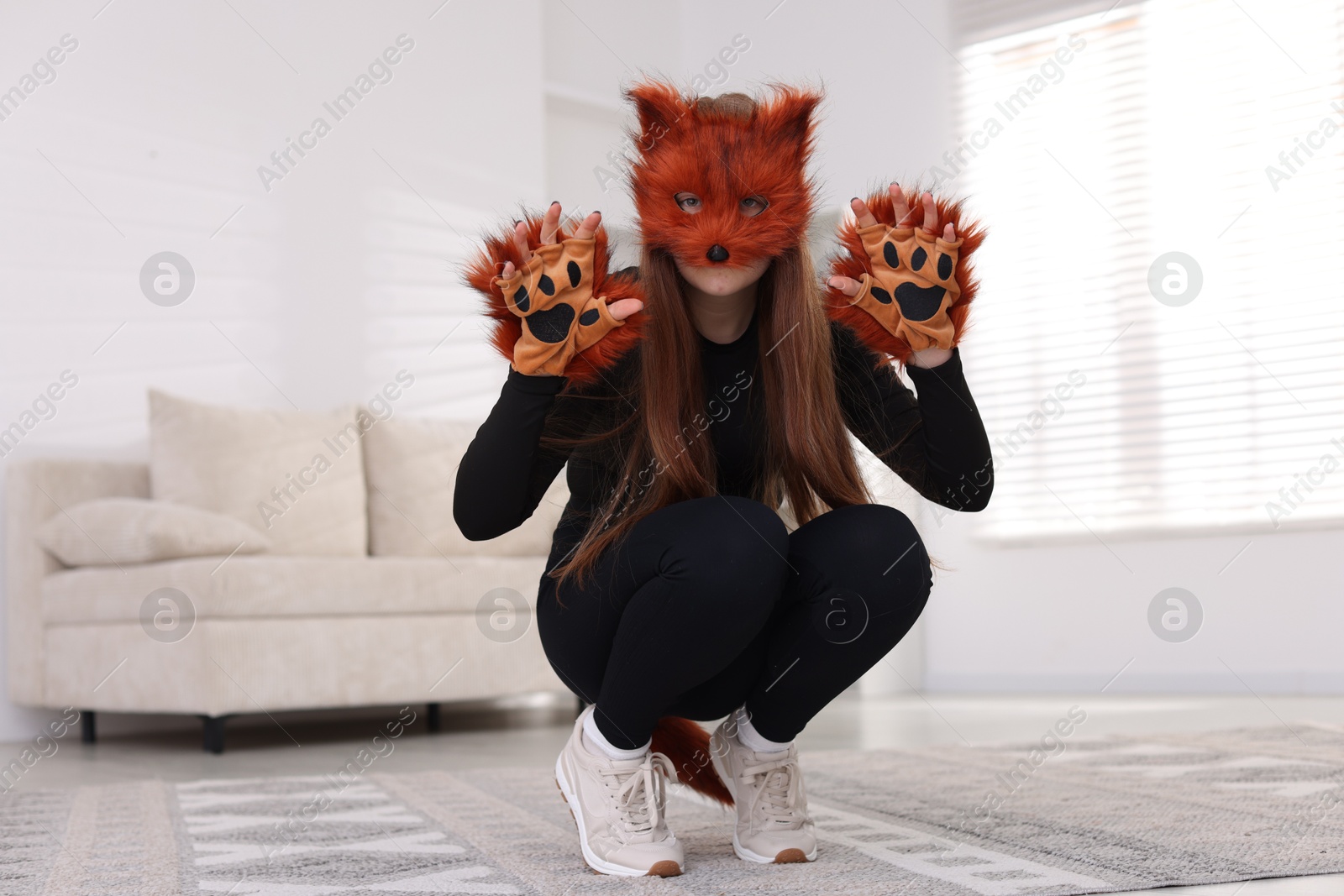 Photo of Quadrobics. Girl wearing fox mask and gloves at home