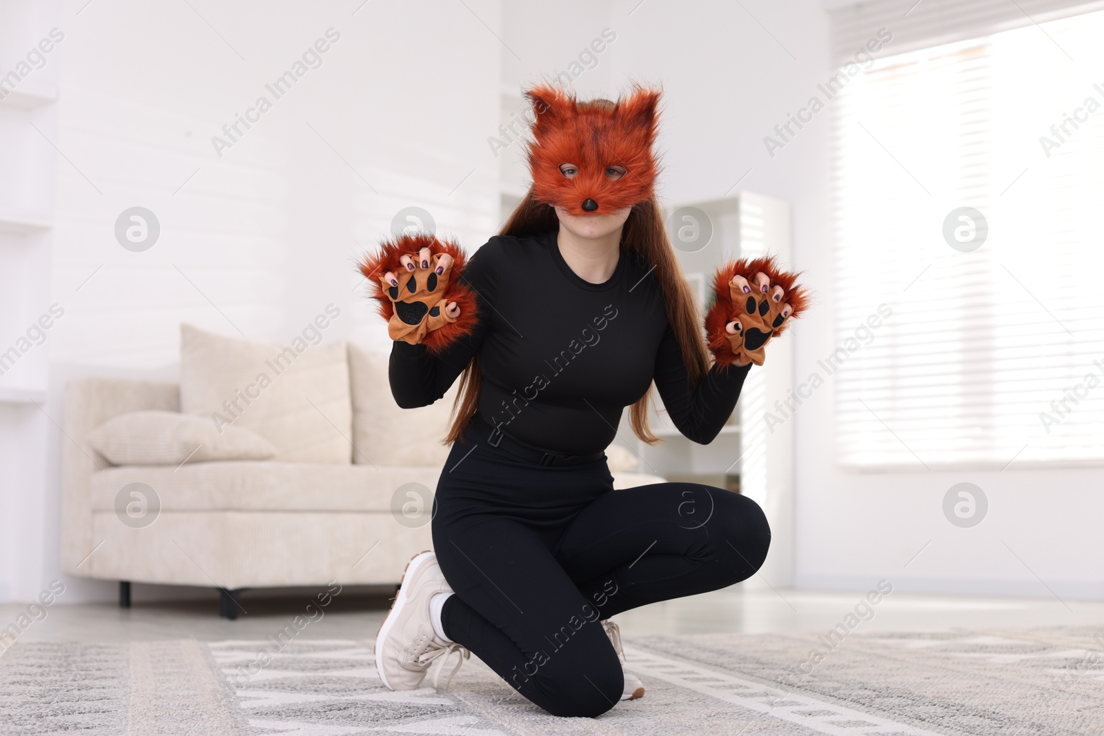 Photo of Quadrobics. Girl wearing fox mask and gloves at home