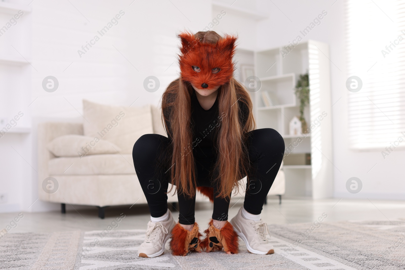 Photo of Quadrobics. Girl wearing fox mask and gloves at home