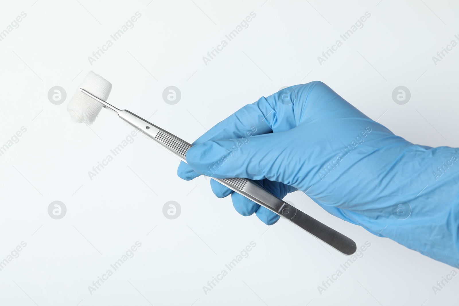 Photo of Doctor holding surgical tweezers with gauze on white background, closeup