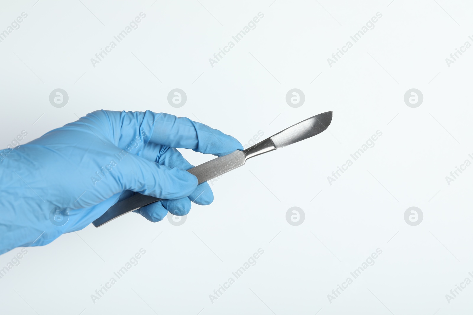 Photo of Doctor with surgical scalpel on white background, closeup. Space for text