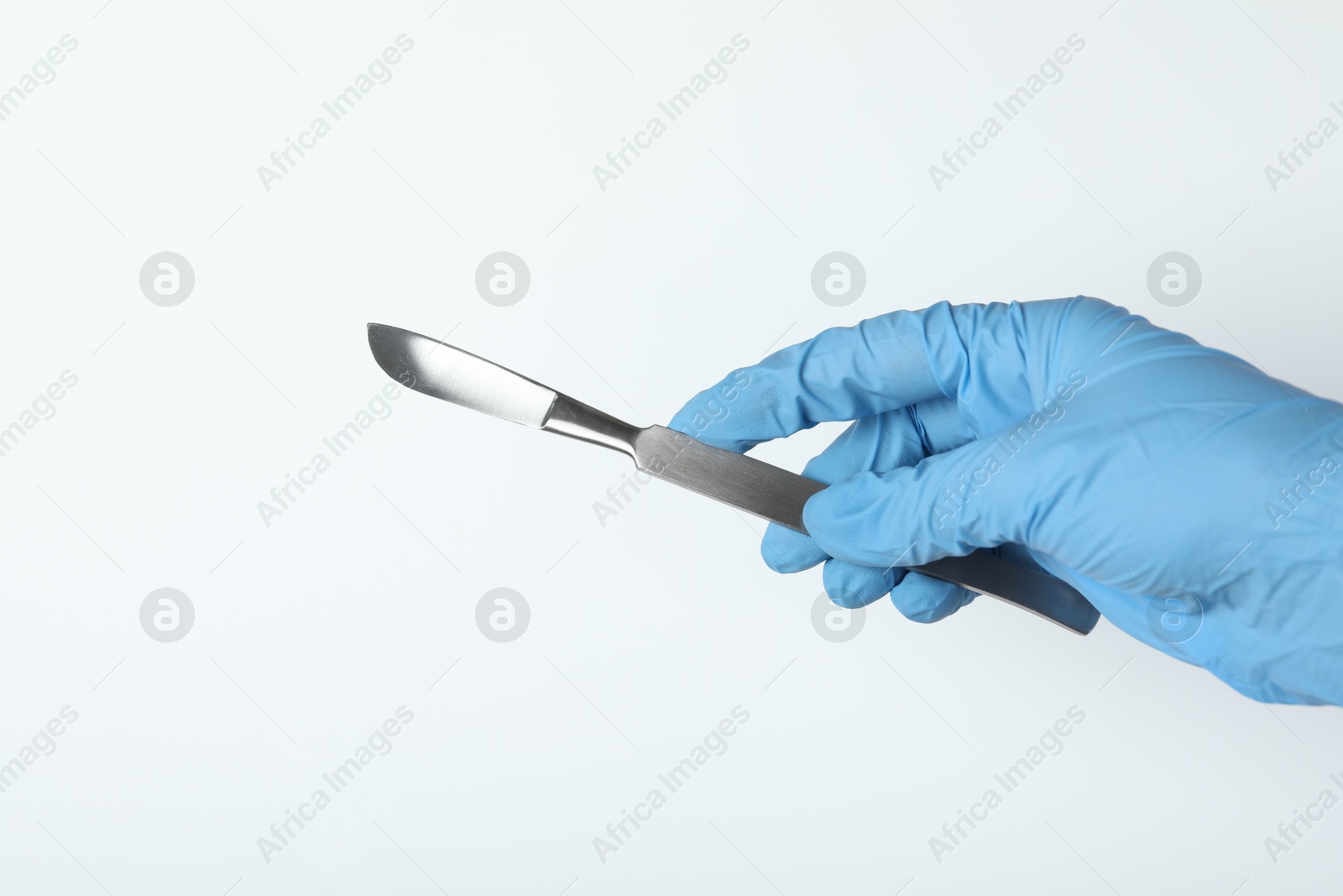 Photo of Doctor with surgical scalpel on white background, closeup. Space for text