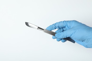 Photo of Doctor with surgical scalpel on white background, closeup. Space for text