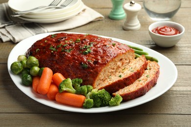 Photo of Delicious baked turkey meatloaf with vegetables served on wooden table, closeup