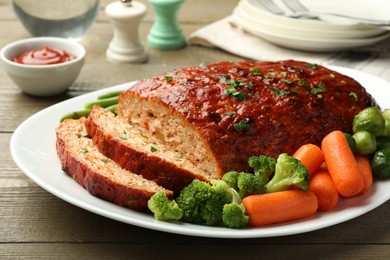 Photo of Delicious baked turkey meatloaf with vegetables served on wooden table, closeup