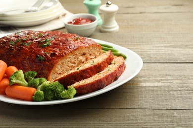 Photo of Delicious baked turkey meatloaf with vegetables served on wooden table, closeup. Space for text