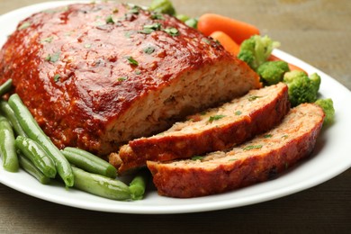 Photo of Delicious baked turkey meatloaf with vegetables on table, closeup