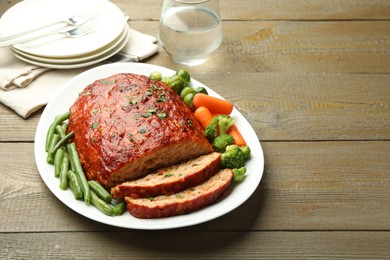 Photo of Delicious baked turkey meatloaf with vegetables served on wooden table, space for text