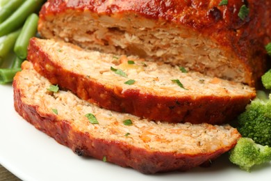 Photo of Delicious baked turkey meatloaf with vegetables on plate, closeup