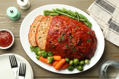 Photo of Delicious baked turkey meatloaf with vegetables served on wooden table, flat lay