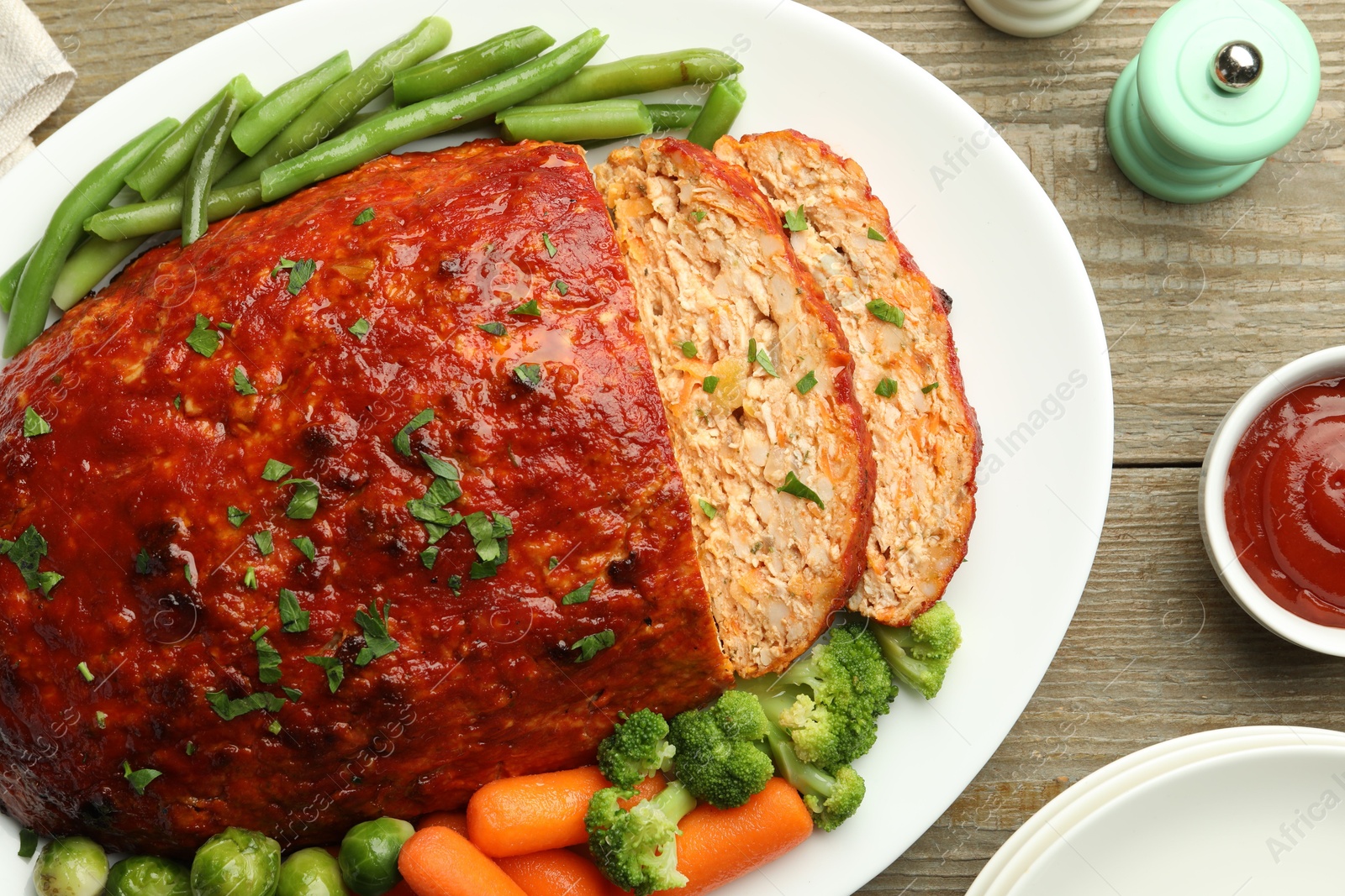 Photo of Delicious baked turkey meatloaf with vegetables served on wooden table, flat lay