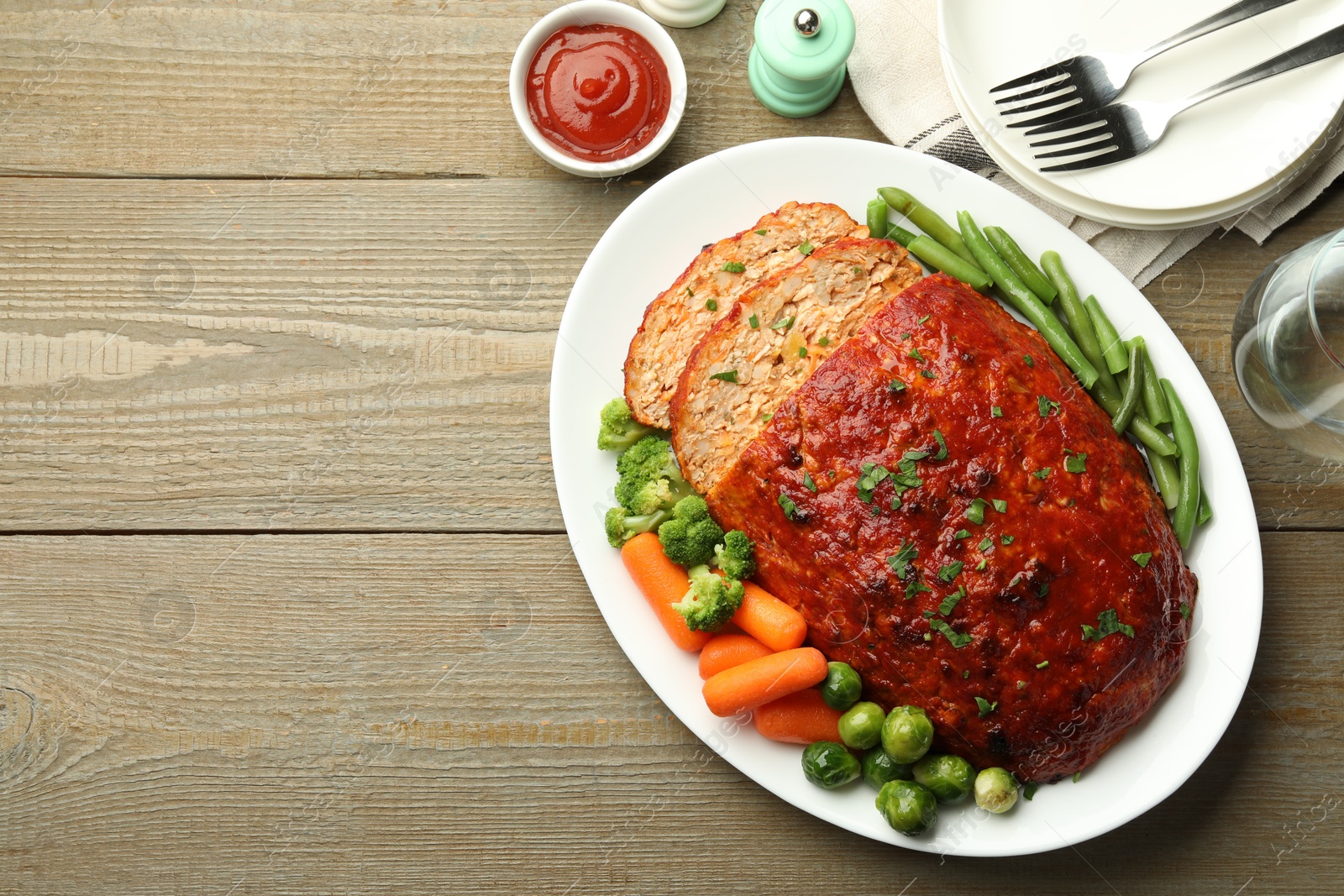 Photo of Delicious baked turkey meatloaf with vegetables served on wooden table, flat lay. Space for text