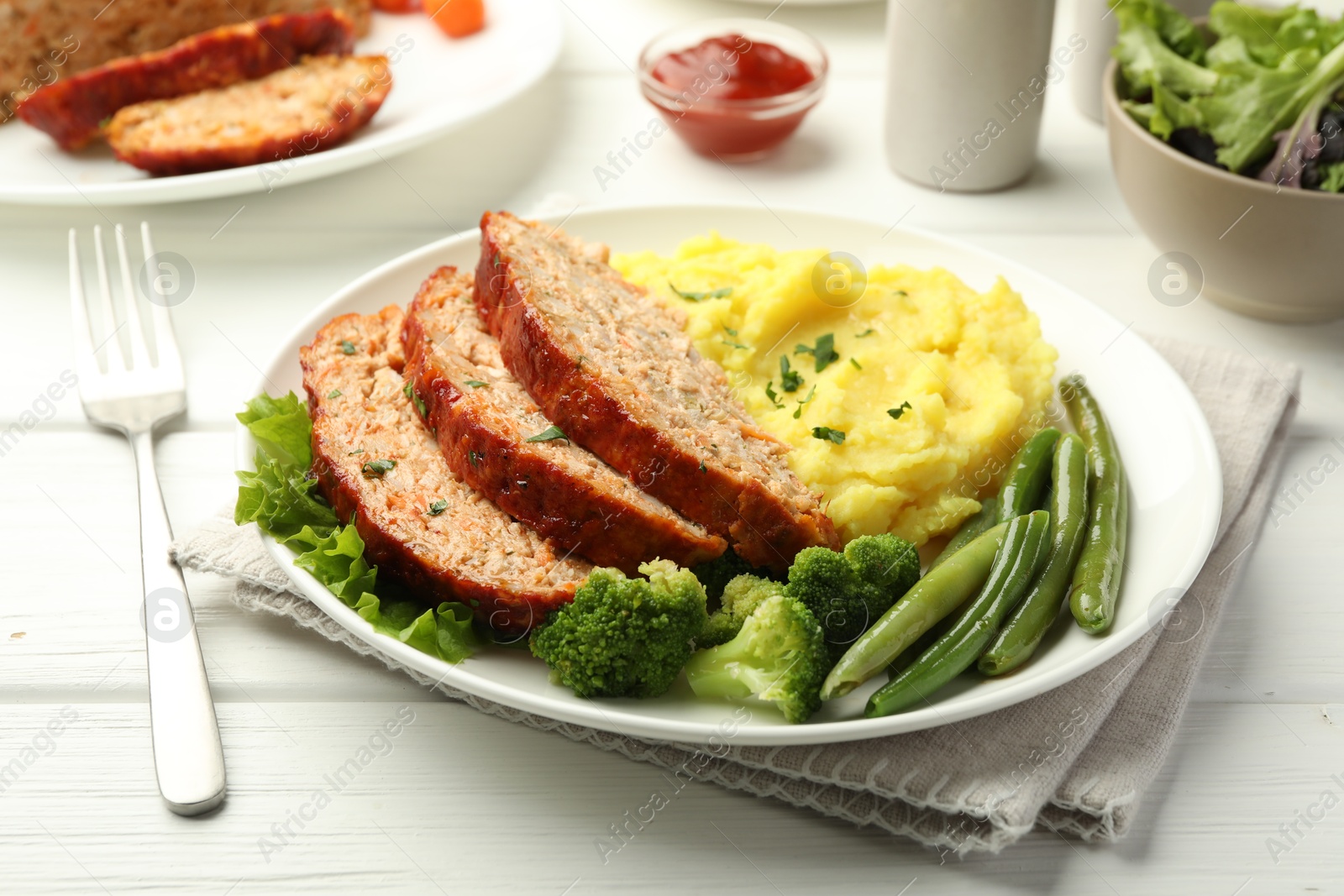 Photo of Delicious baked turkey meatloaf with mashed potato served on white wooden table, closeup