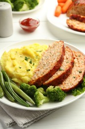 Photo of Delicious baked turkey meatloaf with mashed potato served on white wooden table, closeup