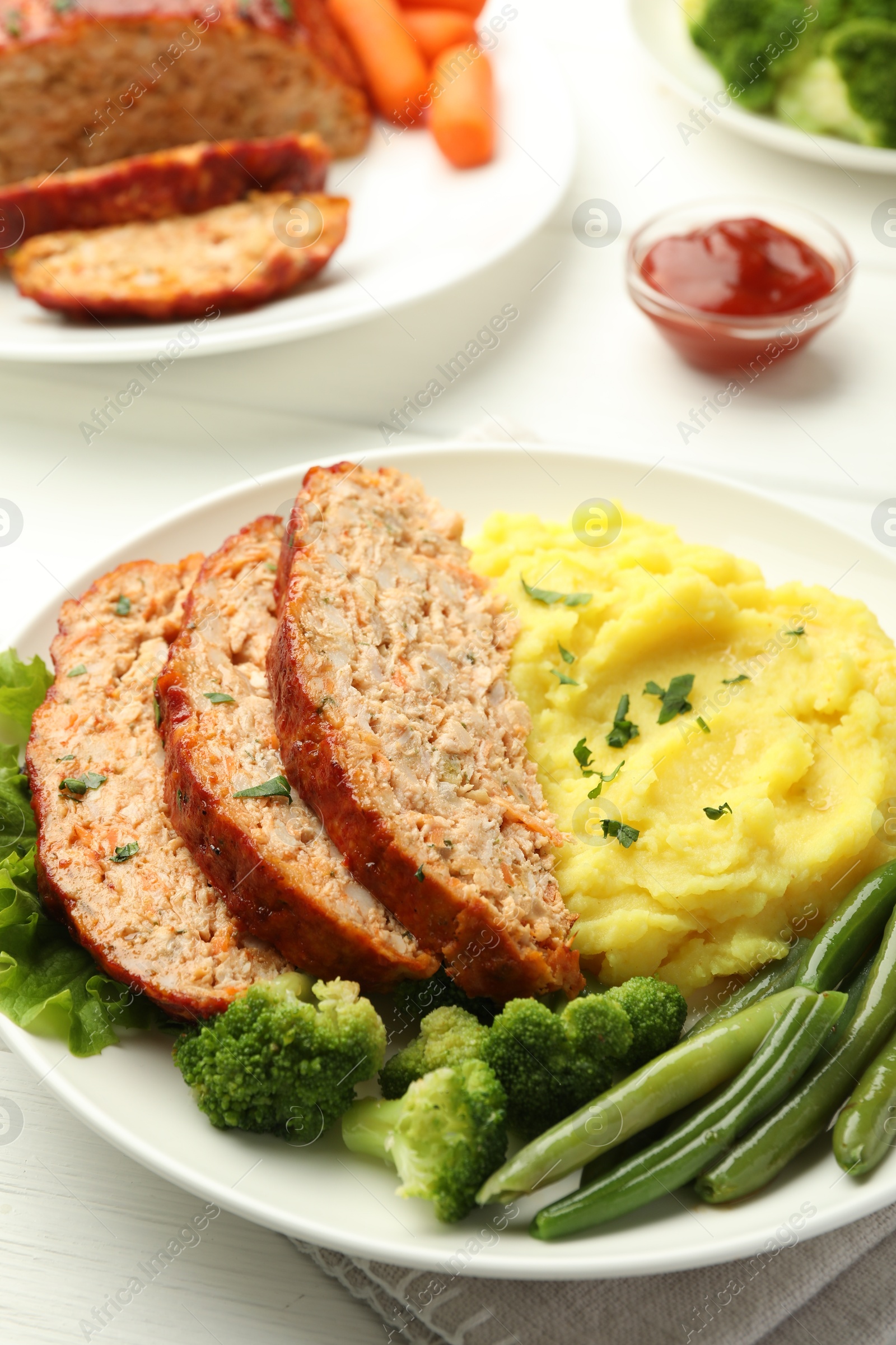 Photo of Delicious baked turkey meatloaf with mashed potato served on white table, closeup