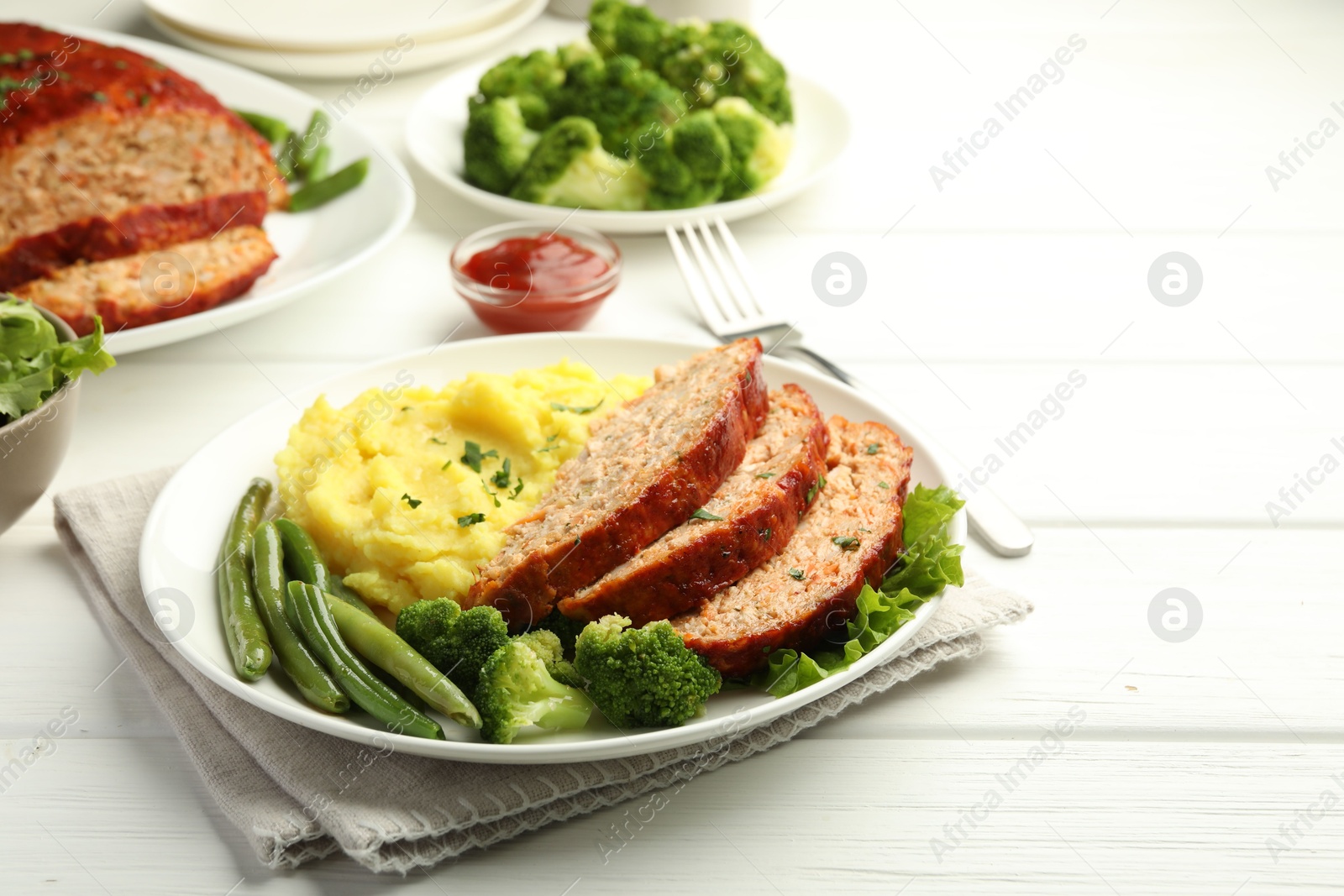 Photo of Delicious baked turkey meatloaf with mashed potato served on white wooden table, closeup. Space for text