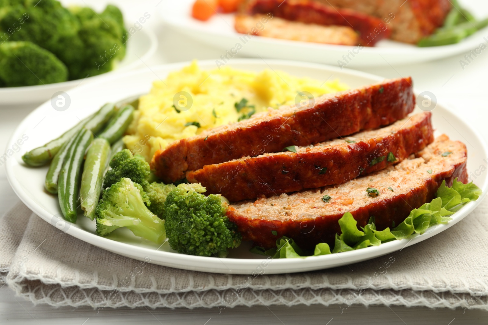 Photo of Delicious baked turkey meatloaf with mashed potato served on table, closeup