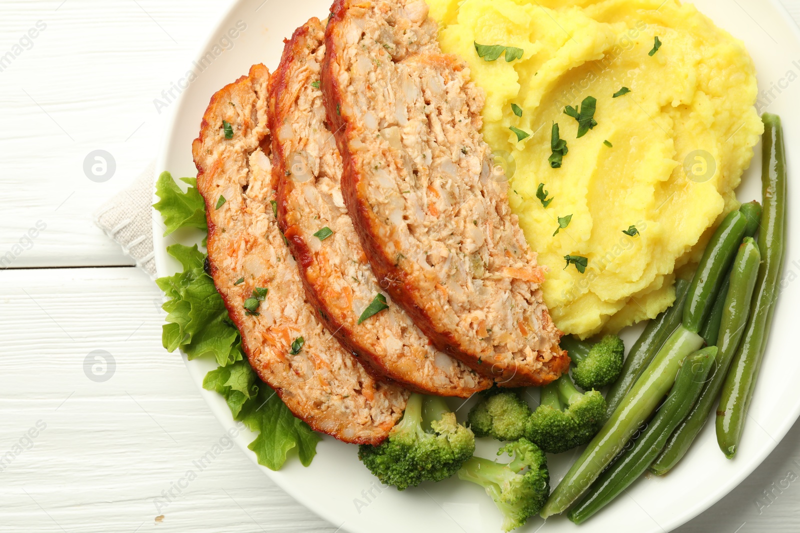 Photo of Delicious baked turkey meatloaf with mashed potato served on white wooden table, top view