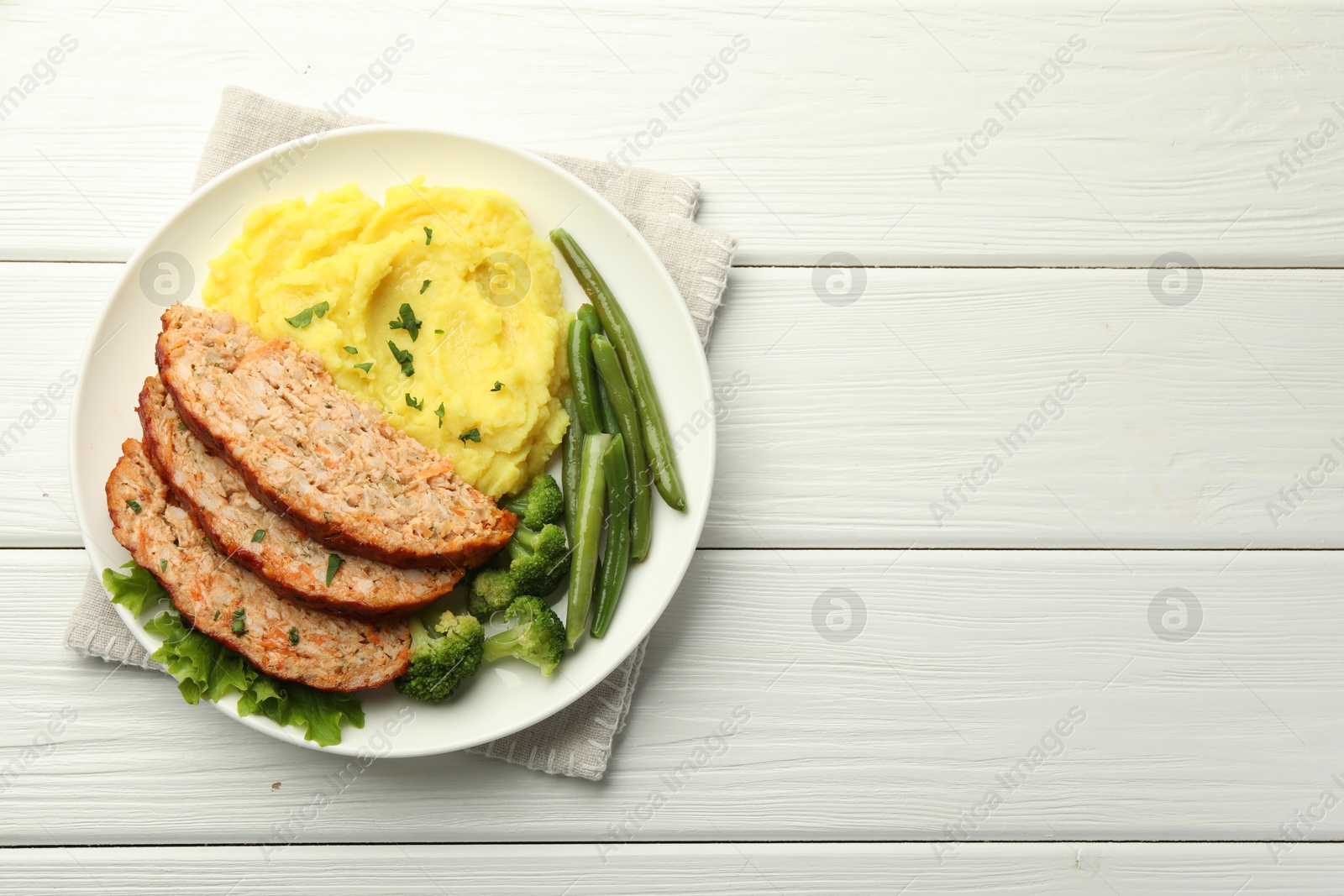 Photo of Delicious baked turkey meatloaf with mashed potato served on white wooden table, top view. Space for text