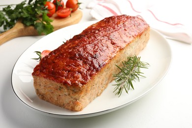 Photo of Delicious baked turkey meatloaf, rosemary, cherry tomatoes and parsley on white table, closeup