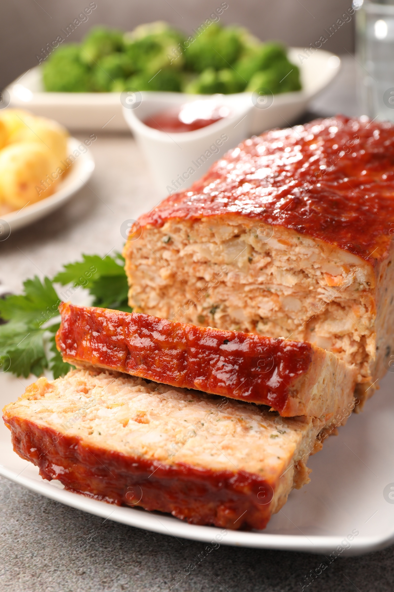 Photo of Delicious baked turkey meatloaf with parsley on grey table, closeup