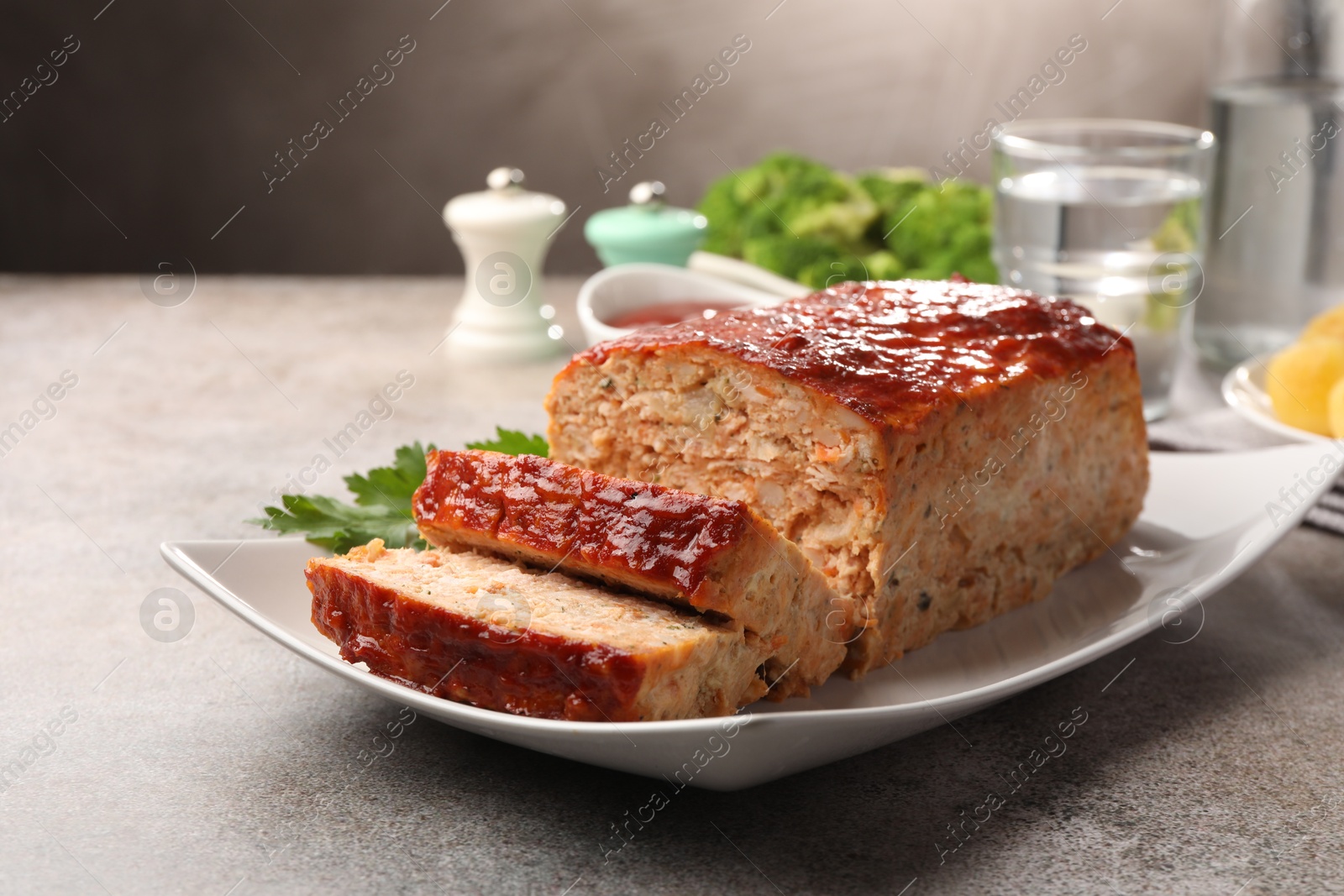 Photo of Delicious baked turkey meatloaf served on grey table, closeup