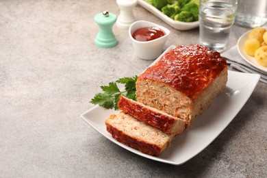 Photo of Delicious baked turkey meatloaf with vegetables served on grey table, closeup. Space for text