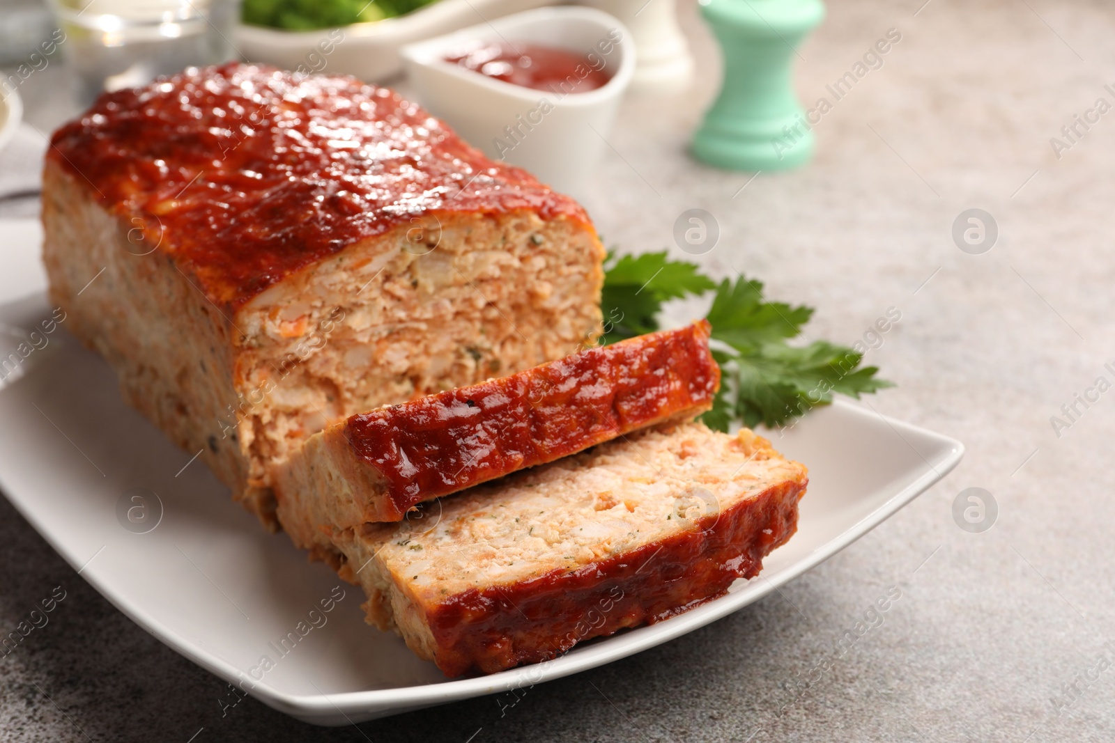 Photo of Delicious baked turkey meatloaf served on grey table, closeup