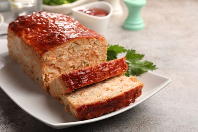 Photo of Delicious baked turkey meatloaf served on grey table, closeup