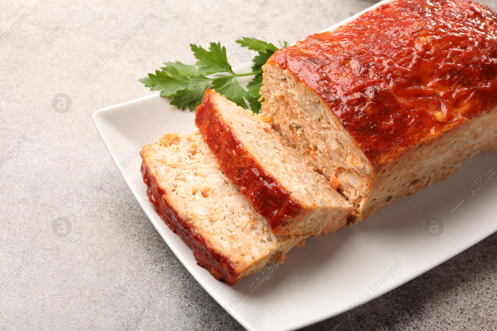 Photo of Delicious baked turkey meatloaf with parsley on grey table, closeup