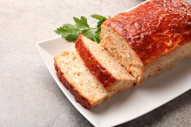 Photo of Delicious baked turkey meatloaf with parsley on grey table, closeup