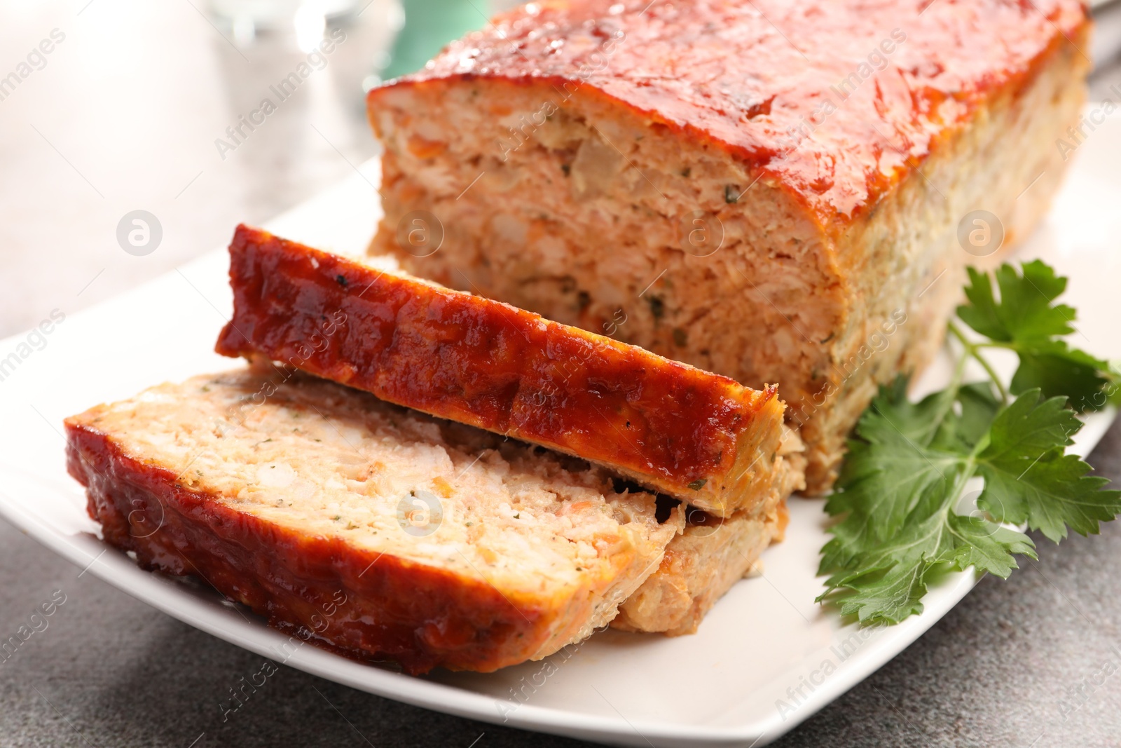 Photo of Delicious baked turkey meatloaf with parsley on grey table, closeup