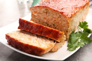 Photo of Delicious baked turkey meatloaf with parsley on grey table, closeup