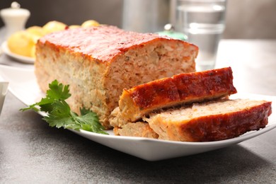 Photo of Delicious baked turkey meatloaf with parsley on grey table, closeup