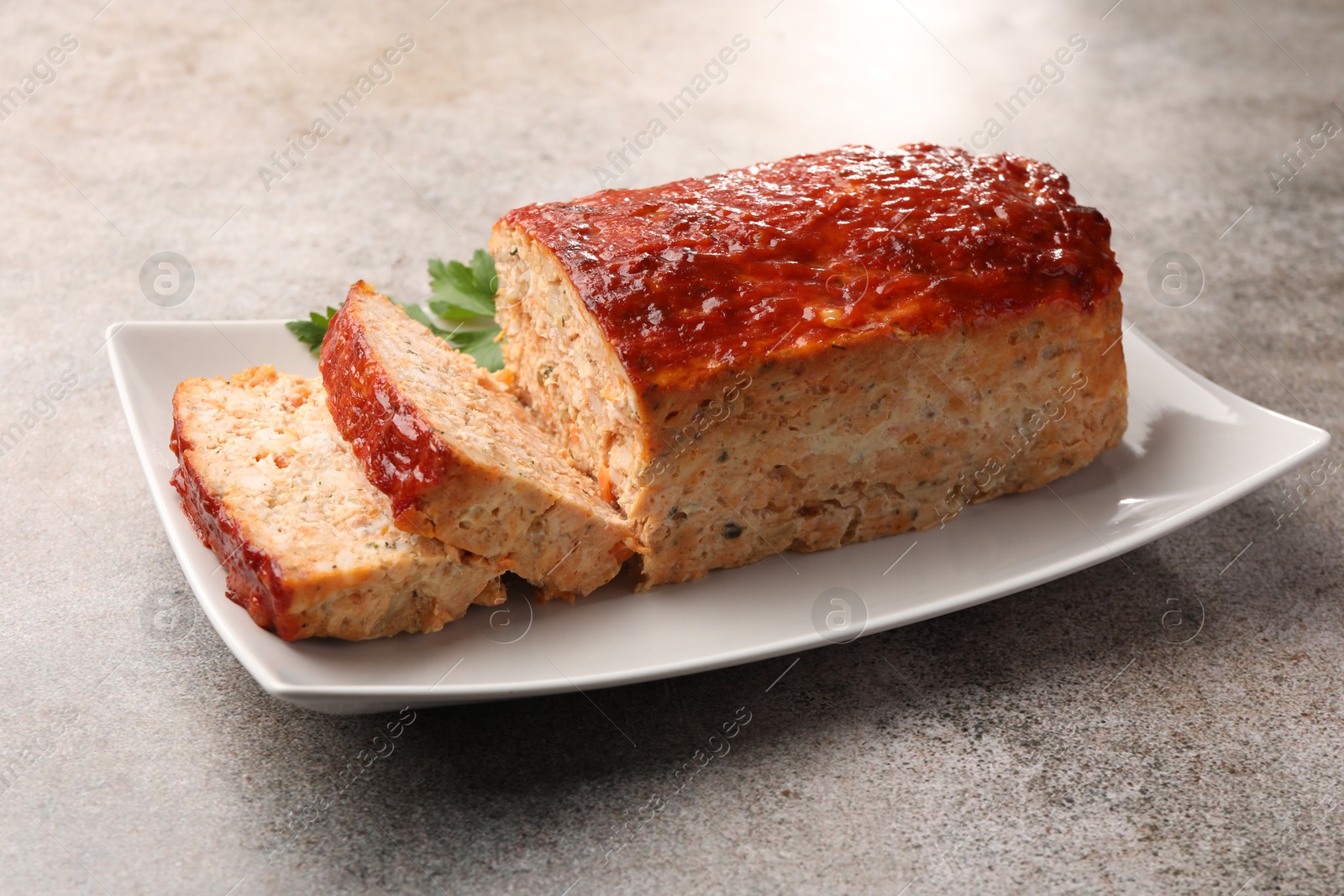 Photo of Delicious baked turkey meatloaf with parsley on grey table, closeup