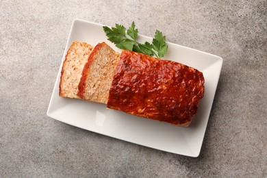 Photo of Delicious baked turkey meatloaf with parsley on grey table, top view