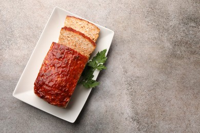 Photo of Delicious baked turkey meatloaf with parsley on grey table, top view. Space for text