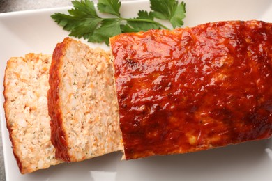 Delicious baked turkey meatloaf with parsley on table, top view